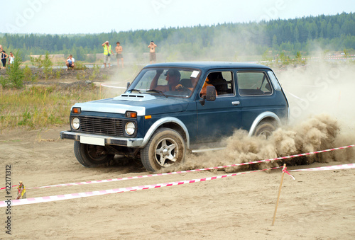 Auto racing trial in the sand pit. Four-wheel drive car jumps ov