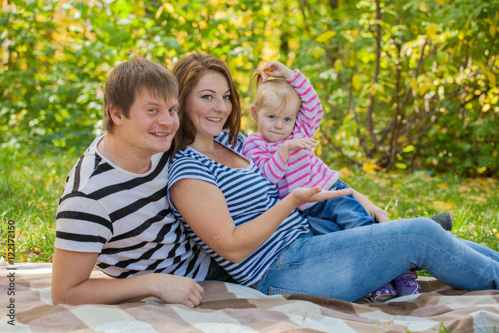 Fototapeta premium happy family in autumn park in the same dress at a picnic