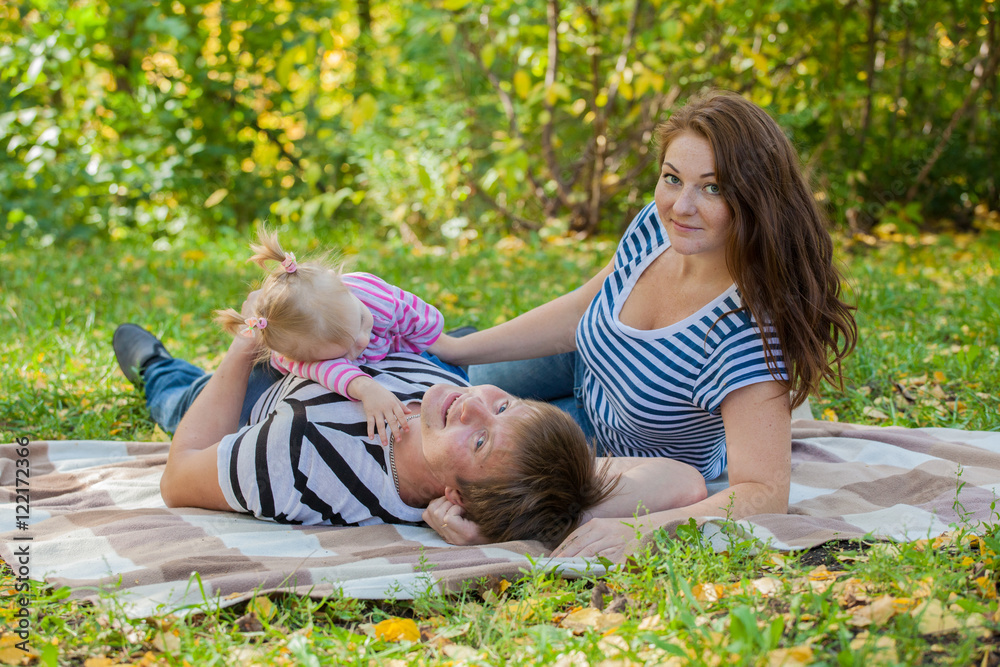 happy family in autumn park in the same dress at a picnic happy family in autumn park in the same dress at a picnic