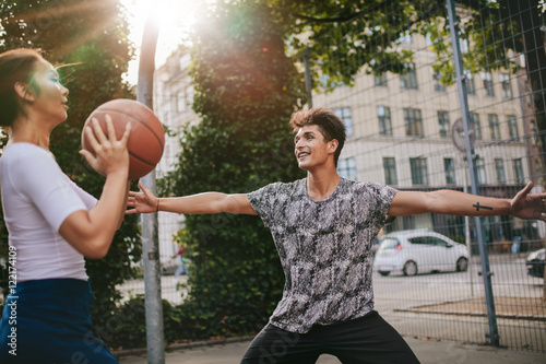 Teenage friends playing streetball against each other