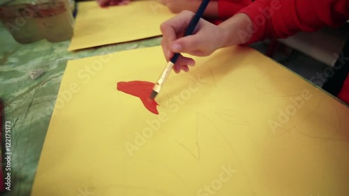 The girl draws a picture paints in classroom photo