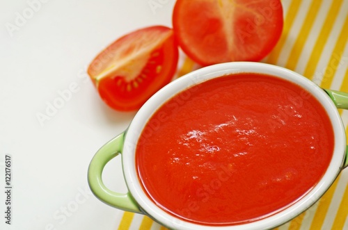 Bowl of tomato sauce on white background with soft focus.