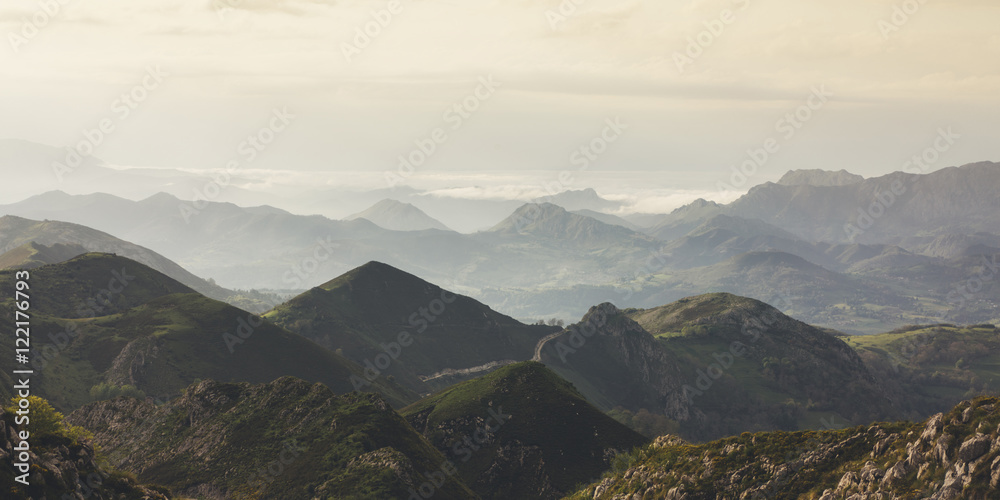 Sunset in the mountain natural landscape. Green valley on background dramatic sky and clouds. Panorama  horizon view of scenery  foggy hills Northern Spain alps. Travel mockup concept in evening time.
