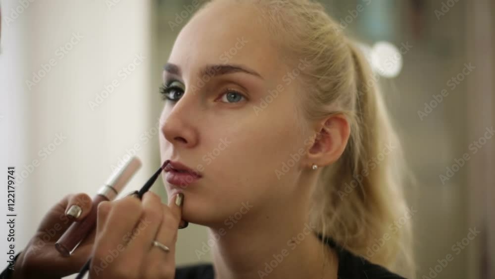 Makeup artist paints her lips, model. Makeup artist paints her lips, model.