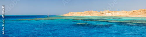 panorama with yellow seashore and emerald water