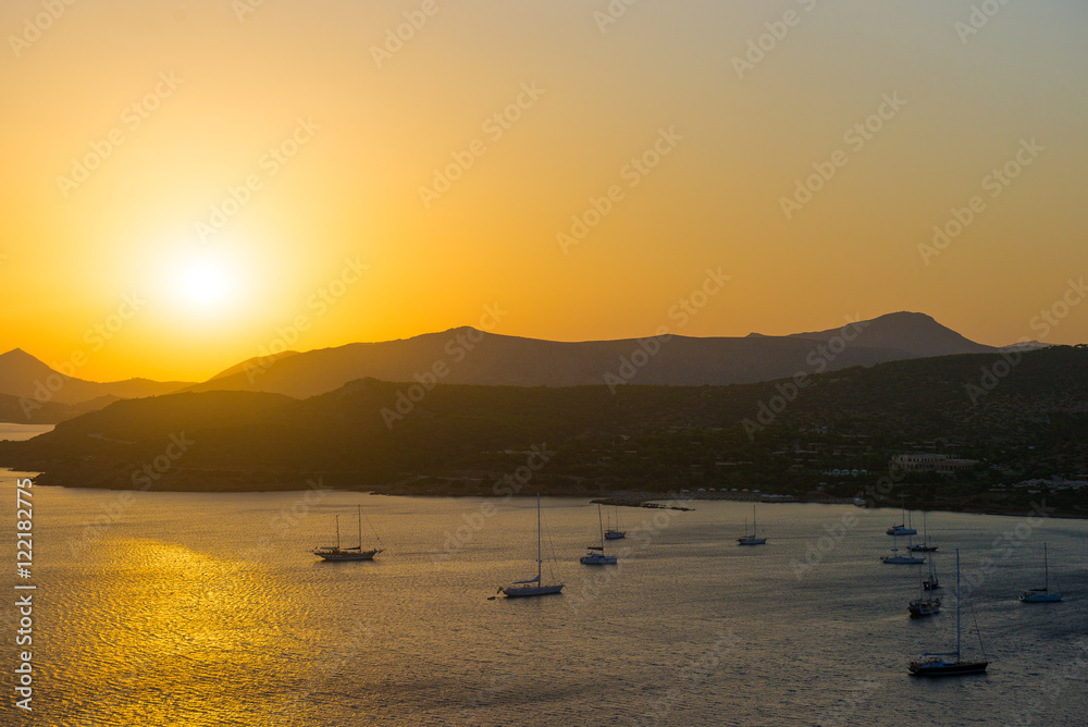 Sunset over the sea. Sunset over the bay with ships. Blur, light mist over the water
