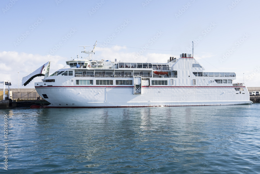 White auto ferry lying at the jetty with blue skies and turquois