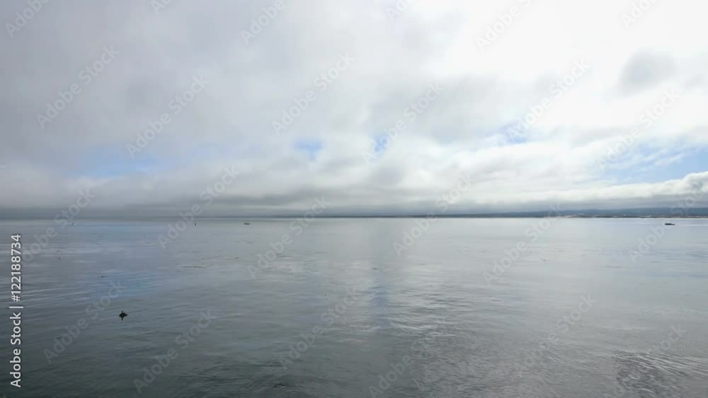 A stationary wide angle landscape view of the ocean bay on a cloudy day. A stationary wide angle landscape view of the ocean bay on a cloudy day.