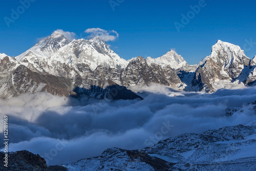 Mount Everest view from Renjo La pass. Amazing mountain valley filled with curly clouds. Dramatic snowy peak of Everest rise above river of clouds. Sagarmatha National Park, Nepal, Himalayas.