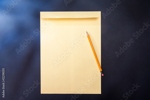 yellow envelope, pencil and paper on isolated background photo