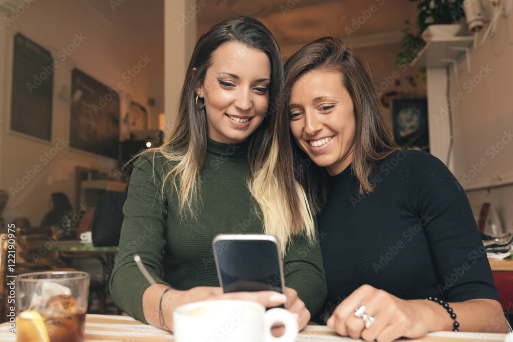 Friends watching social media in a smart phone.