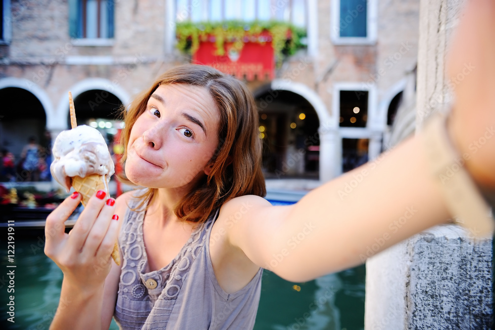 Obraz premium Female traveler making selfie photo with traditional italian ice cream in Venice