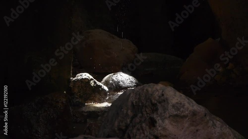   drops of water inside the cave on the rocks sunlit       