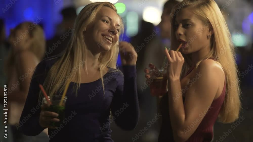 Seductive hot ladies drinking cocktails, moving sexy bodies to music at disco Seductive hot ladies drinking cocktails, moving sexy bodies to music at disco