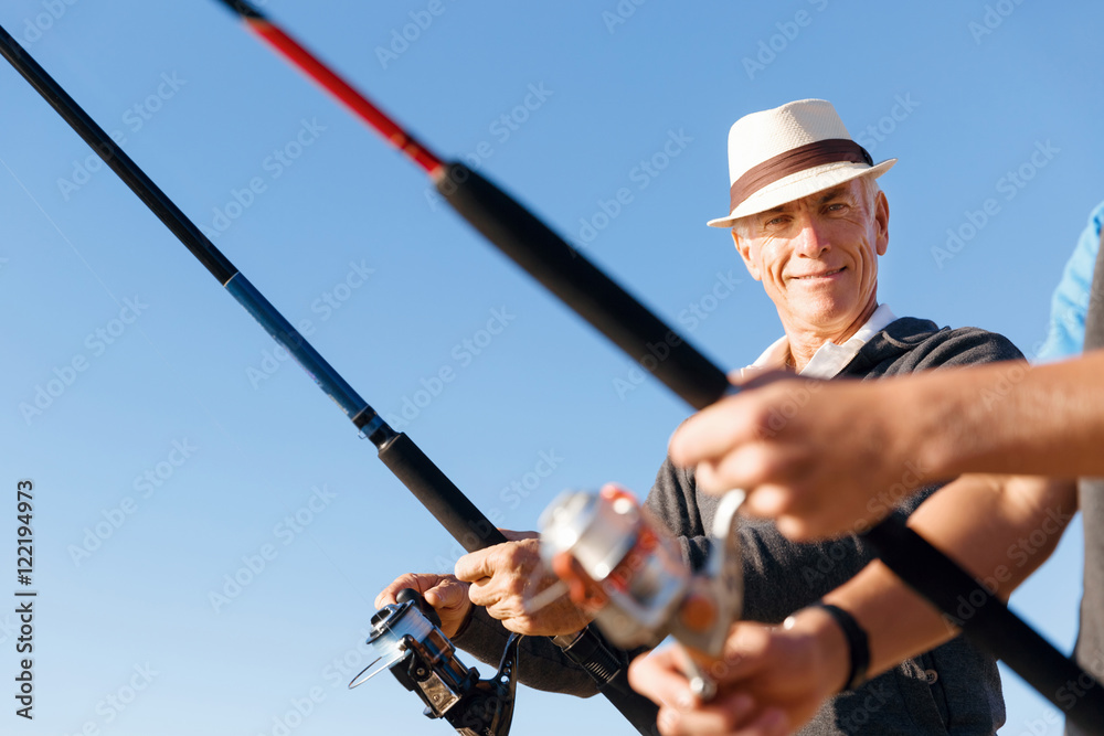 Obraz premium Senior man fishing at sea side