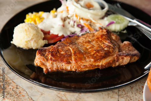 Pork steak, mashed potatoes and salad