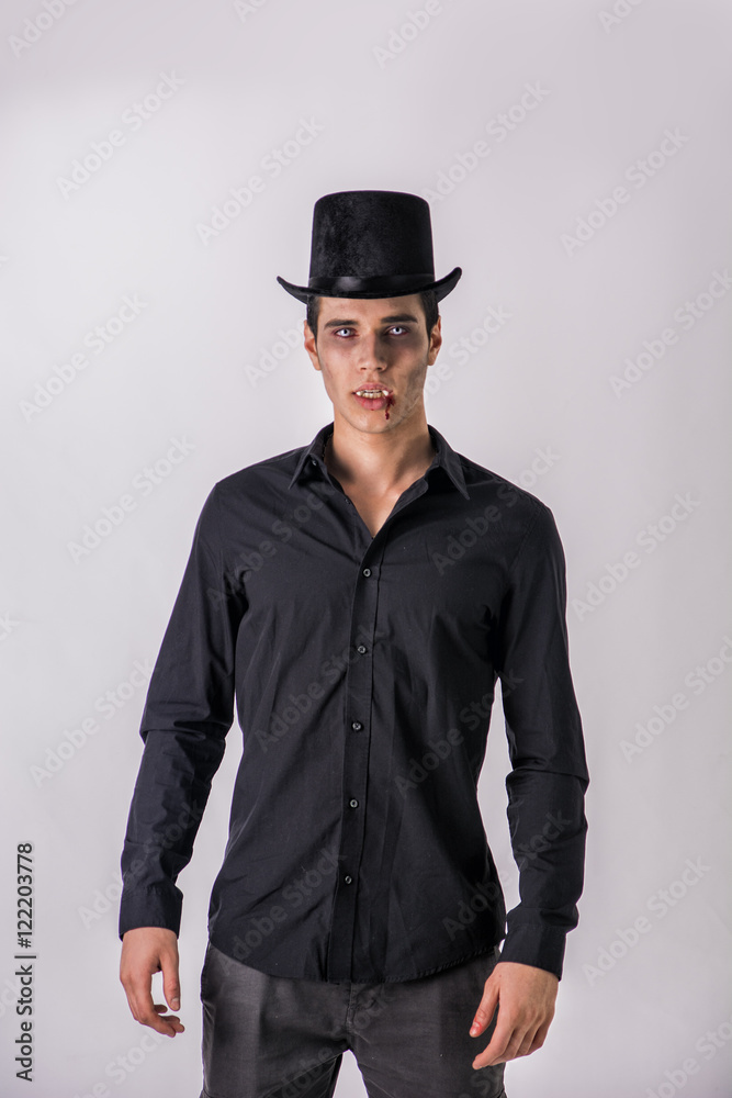 Portrait of a Young Vampire Man with High Hat and Black T-Shirt, Looking at the Camera, On Light Background. Portrait of a Young Vampire Man with High Hat and Black T-Shirt, Looking at the Camera, On Light Background.