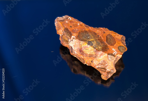 Radial blurred background view of bauxite mineral under sun light on black background