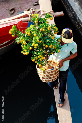 Flowers street vendor at Binh Dong flower market during the Tet Holiday (Lunar New Year), Ho Chi Minh city, Vietnam. Traders bring the plants to the city by boats, and park them at the Tau Hu canal.