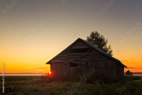 Summer Sunset Behind A Barn House