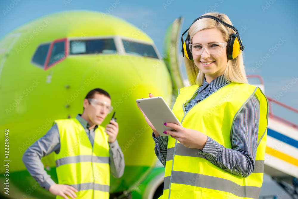 Airport workers with airplane on the background Airport workers with airplane on the background