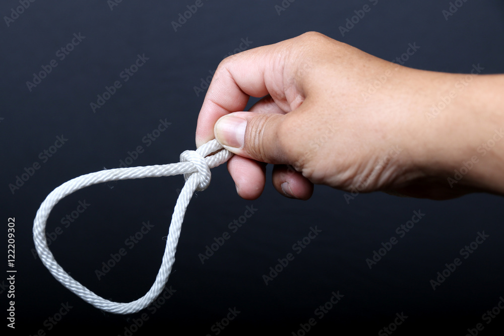 Man's hand holding a loop of rope for hanging  isolated on black background