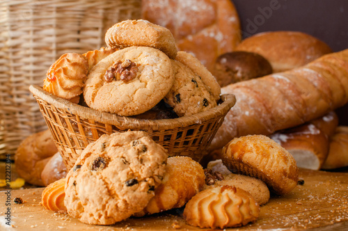 Freshly baked cookies and sweet pastries in the basket on wooden table