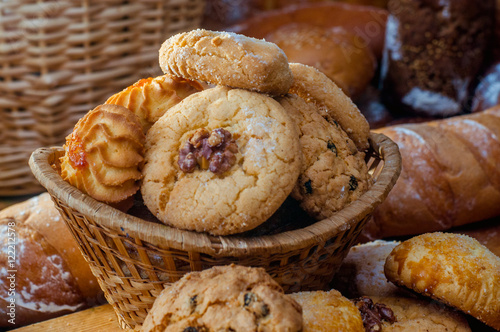 Freshly baked cookies and sweet pastries in the basket on wooden table