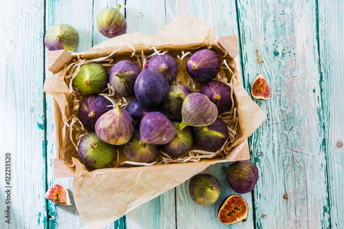 Fotografía Ripe figs in a wooden box on a wooden table.