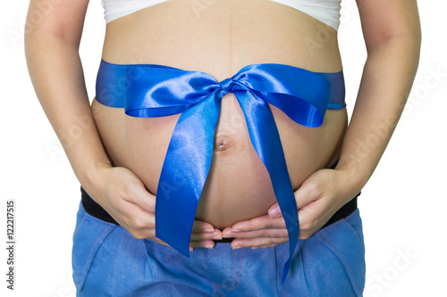 Pregnant woman hands holding belly with blue ribbon gift on bell