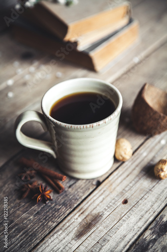 Large Cup of coffee on vintage wooden background. Spring flowers and books.