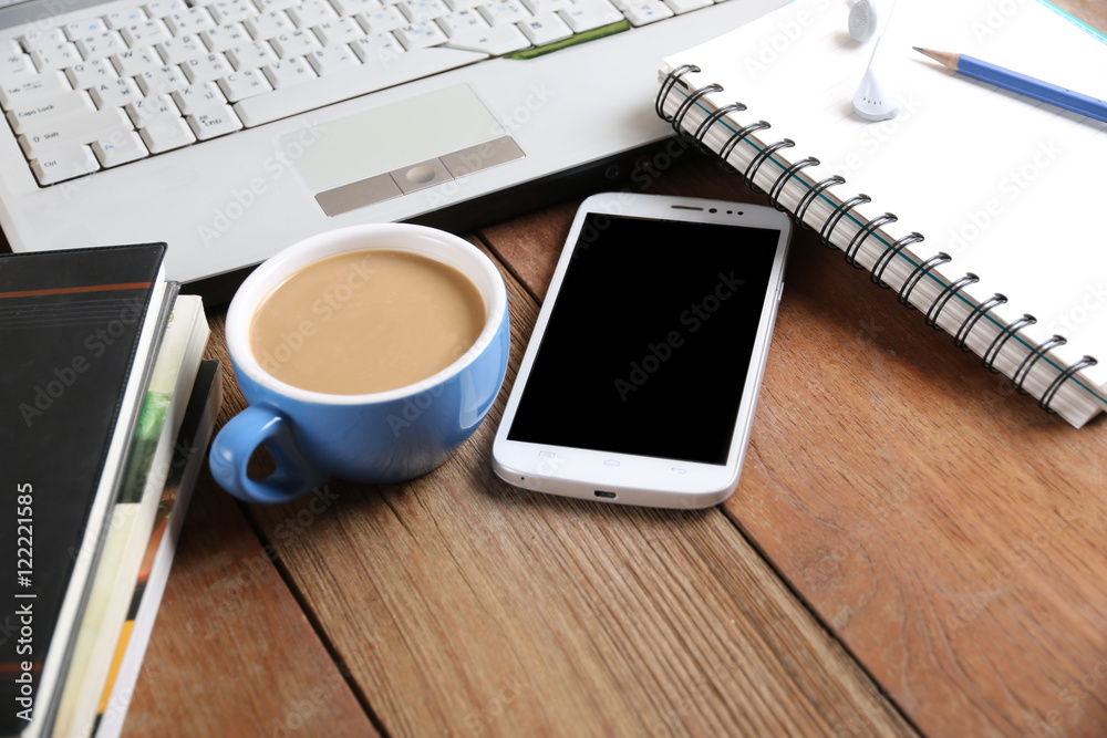 Computers, notebooks, pencils, pens, books, coffee mugs, headset and cell phone on the desk. Computers, notebooks, pencils, pens, books, coffee mugs, headset and cell phone on the desk.