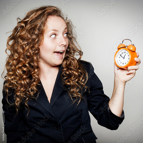 Businesswoman holding clock in hands. Deadline concept with shoc photo