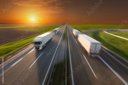 Reefer trucks in motion blur on the empty freeway at sunset © rasica