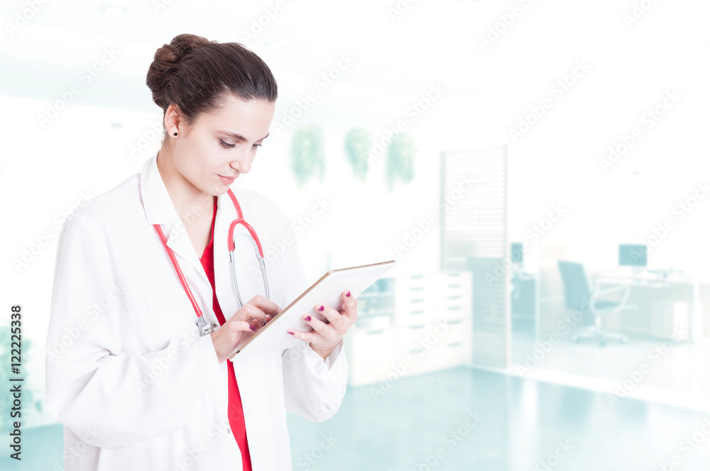 Professional woman medic browsing something on tablet Professional woman medic browsing something on tablet