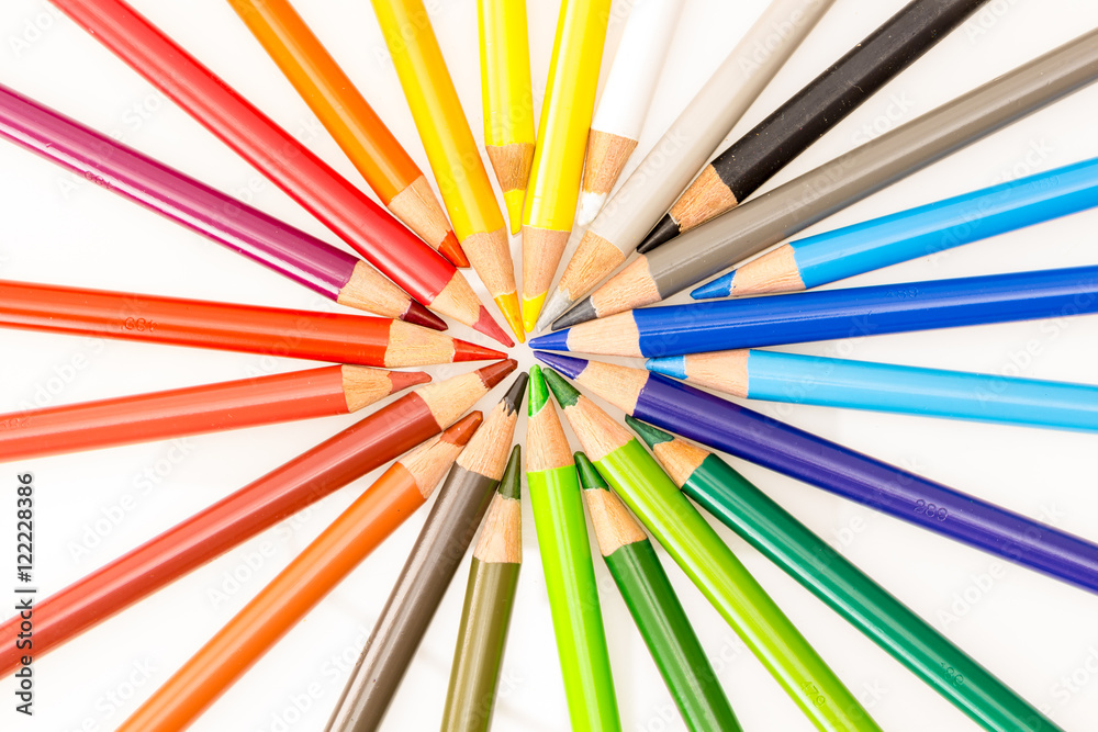 Bunch of colorful pencils set in circle with tips pointing center , on white background