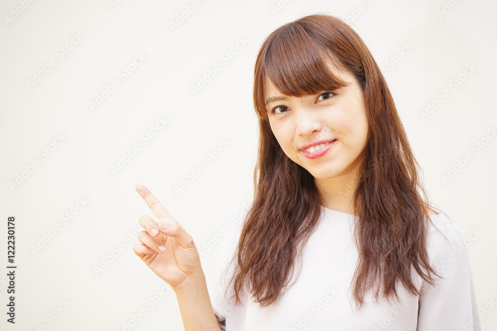 Young Japanese woman pointing something with smile Young Japanese woman pointing something with smile