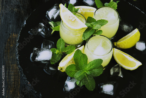 limoncello,Italian traditional liqueur with lemons on the vintage table photo