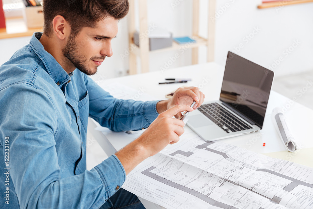 Handsome young businessman taking photo of documents with smartphone Handsome young businessman taking photo of documents with smartphone