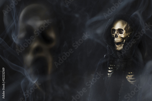 Grim reaper Halloween death character against smokey black background with scream face