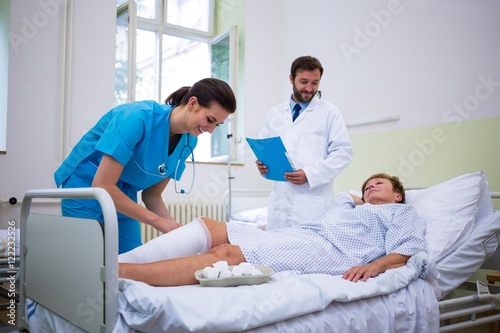 Slika na platnu Nurse bandaging leg of patient