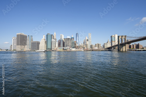 Downtown Manhattan skyline view from Brooklyn of the Brooklyn Bridge with East River in New York City
