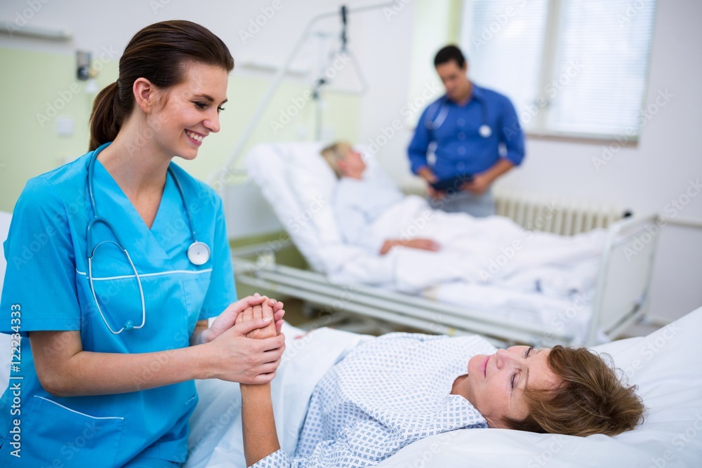 Fototapeta premium Nurse consoling a patient in hospital ward