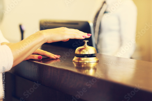 Quadro su tela Guest using reception bell in lobby