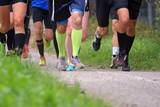 Running competition. Group of men running on a walkway. Closeup of legs.