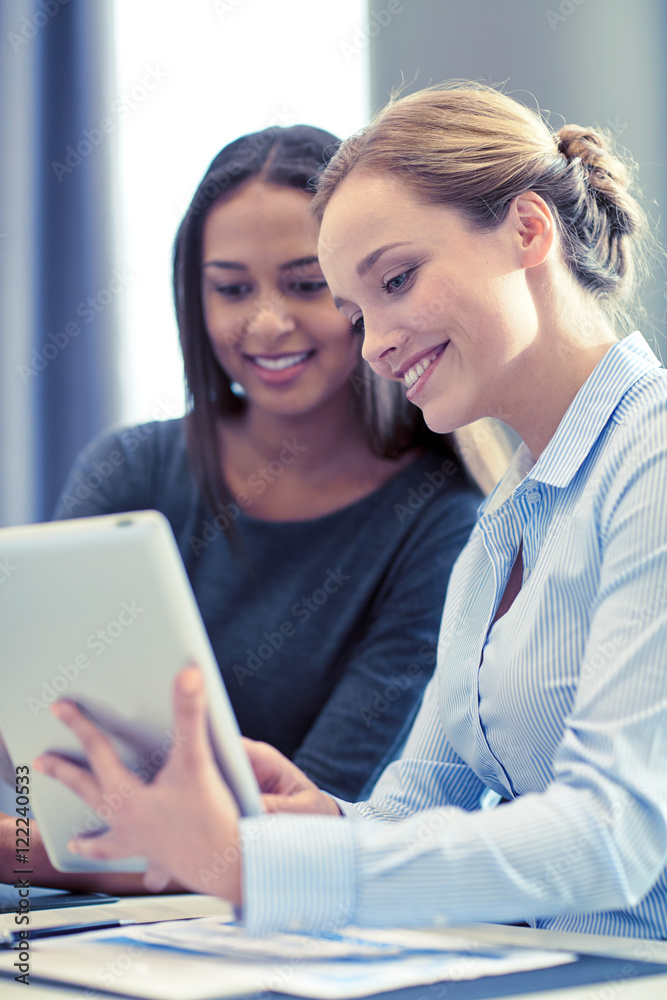 smiling businesswomen with tablet pc in office smiling businesswomen with tablet pc in office