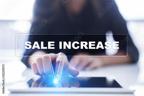 Woman is using tablet pc, pressing on virtual screen and selecting "Sale increase".