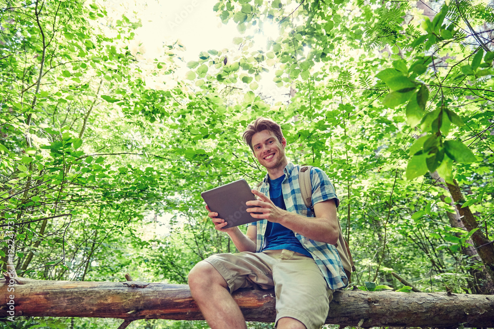 happy man with backpack and tablet pc in woods happy man with backpack and tablet pc in woods