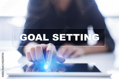 Woman is using tablet pc, pressing on virtual screen and selecting "Goal setting".
