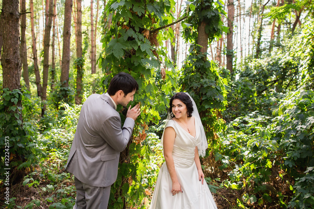 Wedding couple playing and having fun in forest after wedding ceremony Wedding couple playing and having fun in forest after wedding ceremony